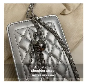 Detail of silver quilted leather bag with adjustable golden ball and chain strap