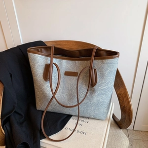 Minimalist large-capacity light blue textile tote bag with brown leather handles and trim