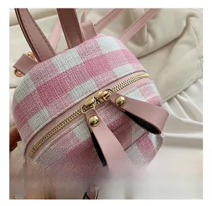 Detail view of pink plaid woven fabric with gold zippers and premium leather pullers