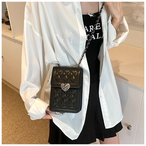 Detail of black quilted leather mini crossbody bag with a silver cracked heart metal buckle