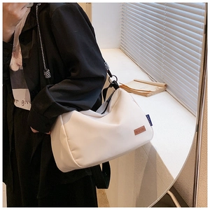 Gros plan sur le patch logo en cuir KEFEIIR et l'étiquette bleue d'un sac cabas en toile crème