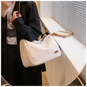 Détail du sac en toile blanc avec étiquette en cuir KEFEIER et bandoulière tissée