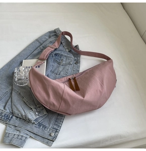 Pink crescent shoulder bag with wide adjustable strap and silver zipper closure detail
