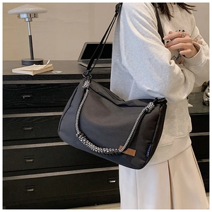 Détail du sac cabas en toile noire avec une corde tressée décorative sur la bandoulière