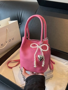 Petit sac seau rose en cuir avec nœud perlé et breloque cœur dans une boîte cadeau