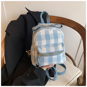 Detail of a mini plaid backpack with a light blue leather bow and zip pocket