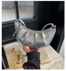 Détail du sac croissant argenté en cuir plissé avec bandoulière à nœud décoratif
