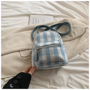 Detailed close-up of light blue checkered mini backpack with fine leather straps