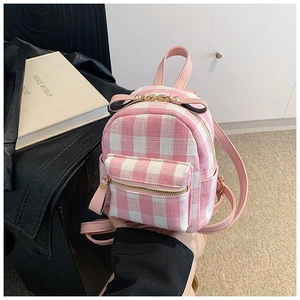 Detail of pink plaid mini backpack with decorative bow and golden chain accent