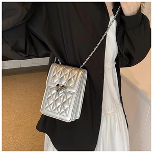 Detail of silver quilted crossbody phone bag with metal heart lock and chain strap