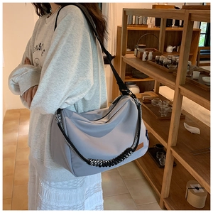 Détail du sac fourre-tout en nylon gris avec forme en croissant et bandoulière tissée