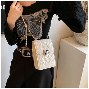 Close-up of quilted white mini bag with silver heart-shaped lock and chain strap