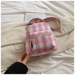 Detail of pink and white checkered tweed mini backpack with gold zippers and leather straps