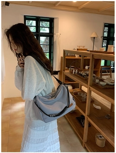 Détail du sac croissant bleu clair en nylon avec bandoulière large et cordon tressé
