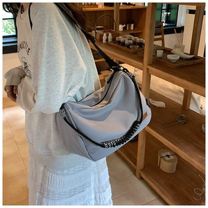 Détail du sac cabas en nylon gris avec poignée tressée noire et blanche et étiquette