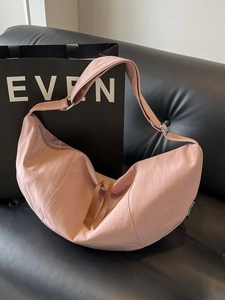Pink large capacity half-moon crossbody bag in vintage Japanese style on leather sofa