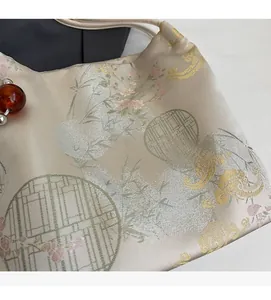 Detail of satin floral embroidery and classic bamboo patterns on the large tote bag