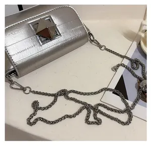 Detailed close-up of a silver chain bag featuring a large 3D pyramid stud and PU texture