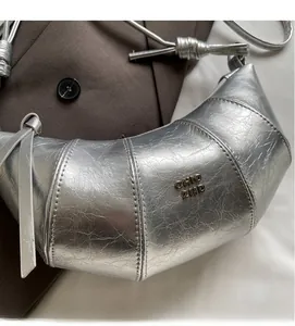 Détail du sac demi-lune argenté métallisé avec plis texturés et logo en métal CHIC 2ND