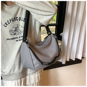 Détail du sac bandoulière en nylon gris avec corde tressée décorative contrastée