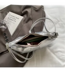 Vue intérieure du sac croissant argenté montrant la capacité pour téléphone et maquillage