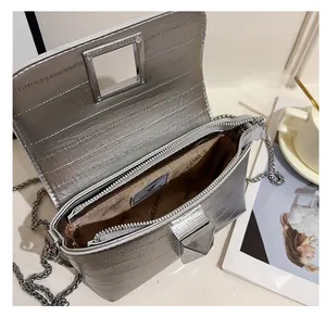 Interior view of silver square crossbody bag with zipper compartments and metal chain