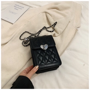 Close-up of quilted pattern leather mini bag with silver heart-shaped metal buckle