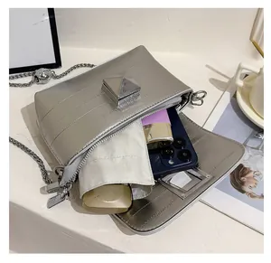 Macro view of silver crossbody bag interior showing space for phone and makeup