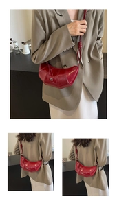 Détail du sac demi-lune bordeaux avec bandoulière nouée et texture matelassée