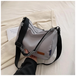 Gros plan d'un grand sac fourre-tout en nylon gris avec bandoulière et logo de marque KEFEIR