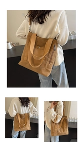 Detailed view of tan canvas tote bag with adjustable straps and front pocket