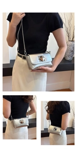 Detail view of silver crossbody bag featuring a pyramid lock and metallic crinkled texture