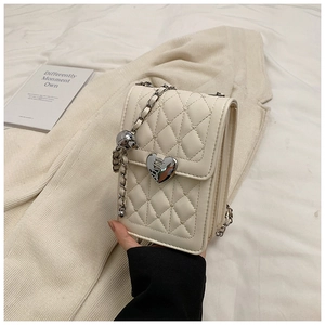 Detail of quilted beige phone bag with heart shaped silver lock and chain strap