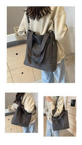 Detail of dark grey canvas tote bag showing side zipper and snap pocket structure