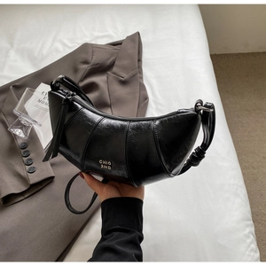 Détail du sac croissant noir brillant avec logo doré CHIO 2ND et texture cuir élégante