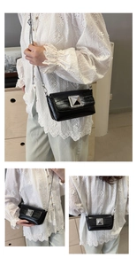 Detail of black glossy crinkled leather crossbody bag with silver square buckle and chain