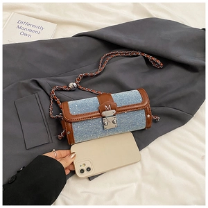 Mini borsa a cilindro in denim mostrata con uno smartphone per il confronto taglie