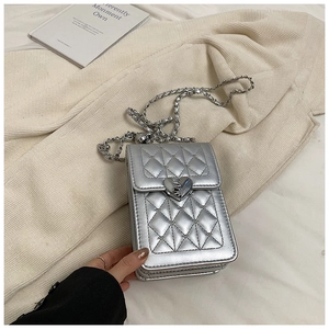 Detail of silver quilted phone bag featuring a heart clasp and metal chain strap