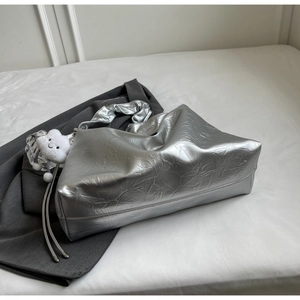 Detail of silver metallic tote bag with crinkled texture and white cloud plush charm