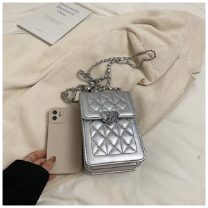 Silver quilted chain phone bag showing internal capacity with a smartphone