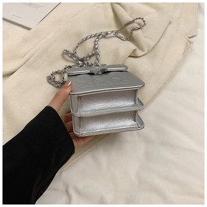 Detail view of silver quilted mini crossbody bag with dual-compartment accordion structure