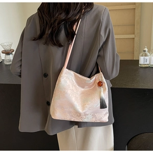 Detail of pink jacquard tote bag featuring traditional Chinese embroidery and tassel
