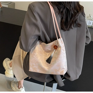 Detail of embroidered landscape pattern and tassel charm on pink Chinese style tote bag