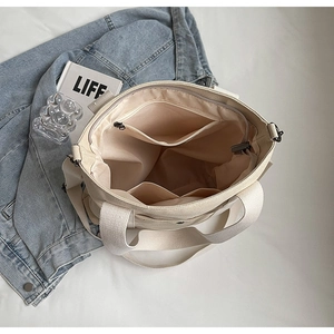 Detailed top view of large canvas tote bag showing interior lining and zipper pockets
