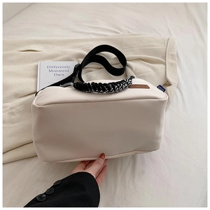 Détail du sac bandoulière en toile blanc cassé avec poignée tissée et sangle noire