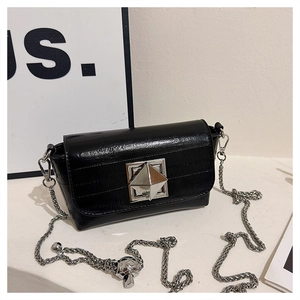 Detail of silver diamond lock and chain strap on black minimalist square bag