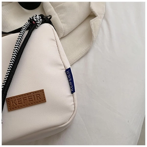 Détails de l'étiquette en cuir KEFEIR et de la corde tressée sur le sac en toile