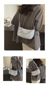 Détail du sac sous le bras en tweed bleu clair avec chaîne argentée et breloque noeud papillon