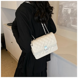 Detail of silver metal chain strap and DP press-lock on white quilted leather crossbody bag