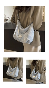Detailed view of light blue hobo bag with silver chain and adjustable wide strap